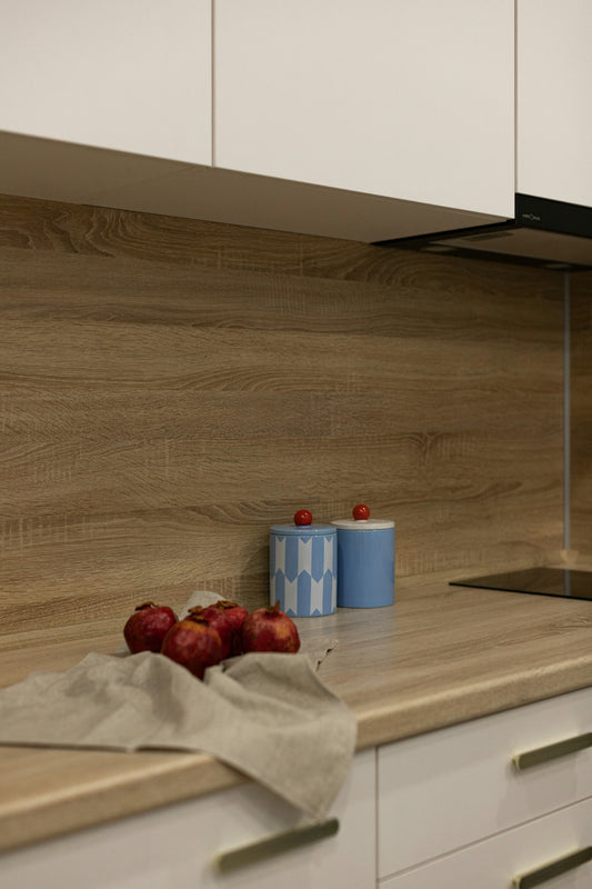 Red apples on a kitchen counter with canisters.